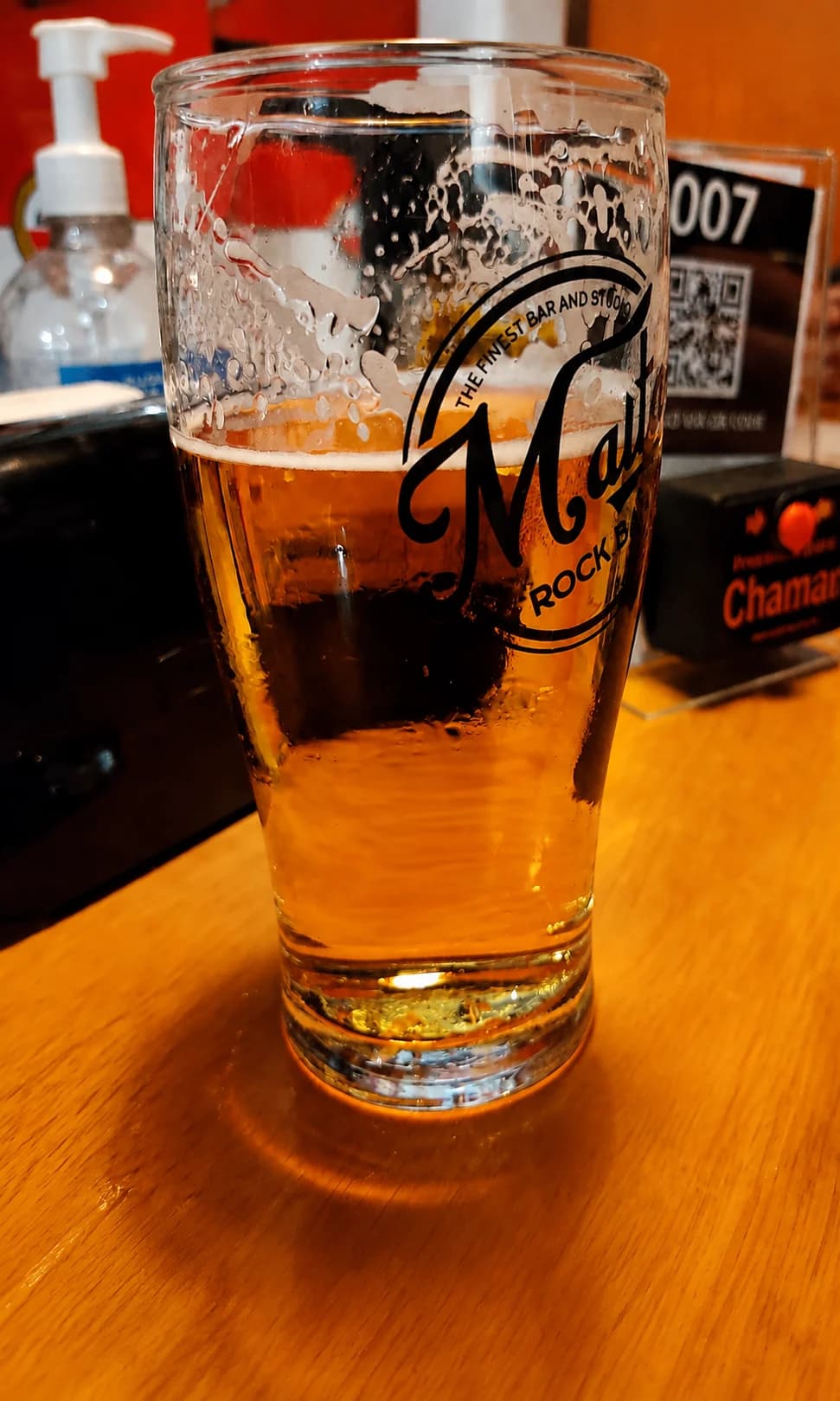 Copo de chope do Malta Rock Bar sobre uma mesa de madeira
